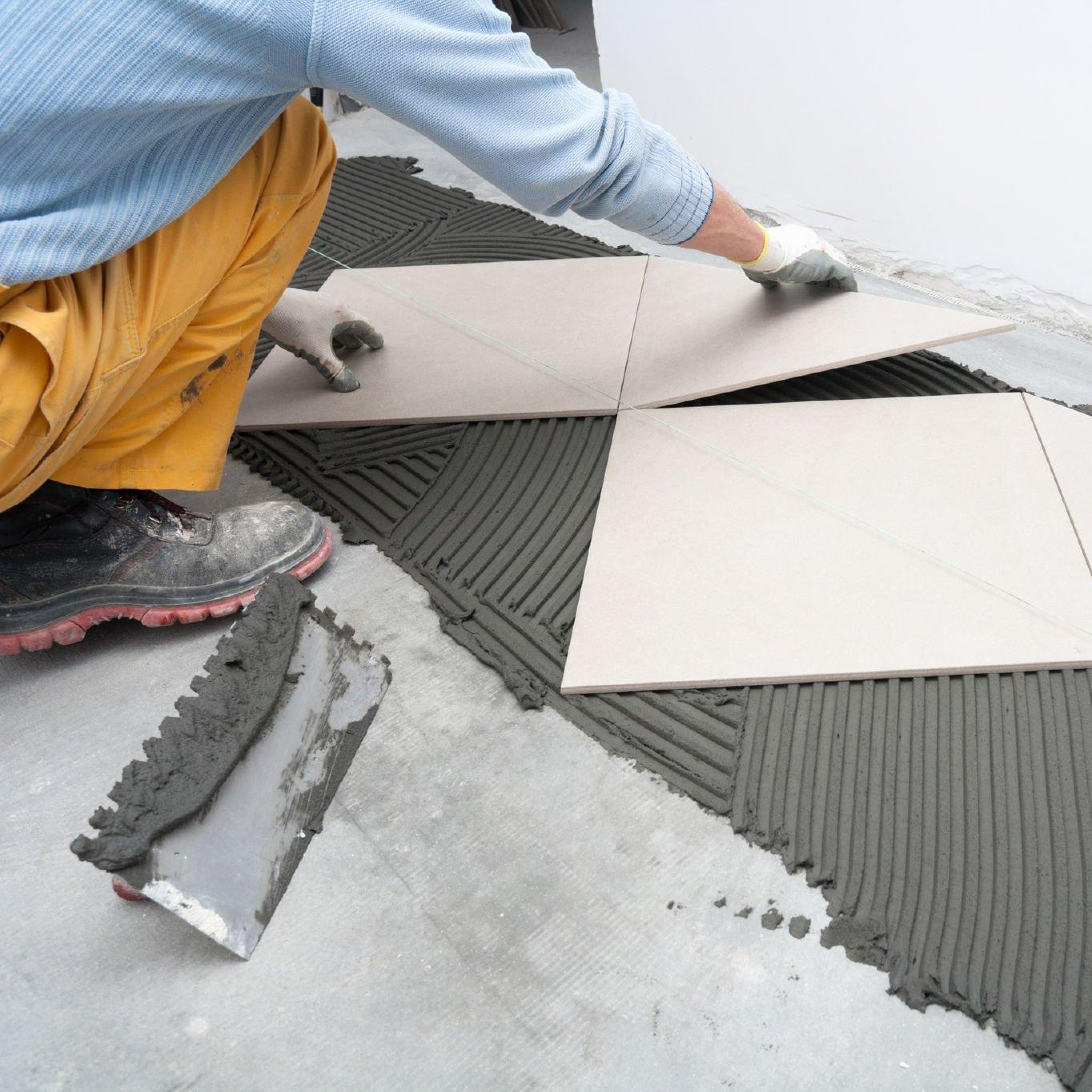 man installing floor tiles